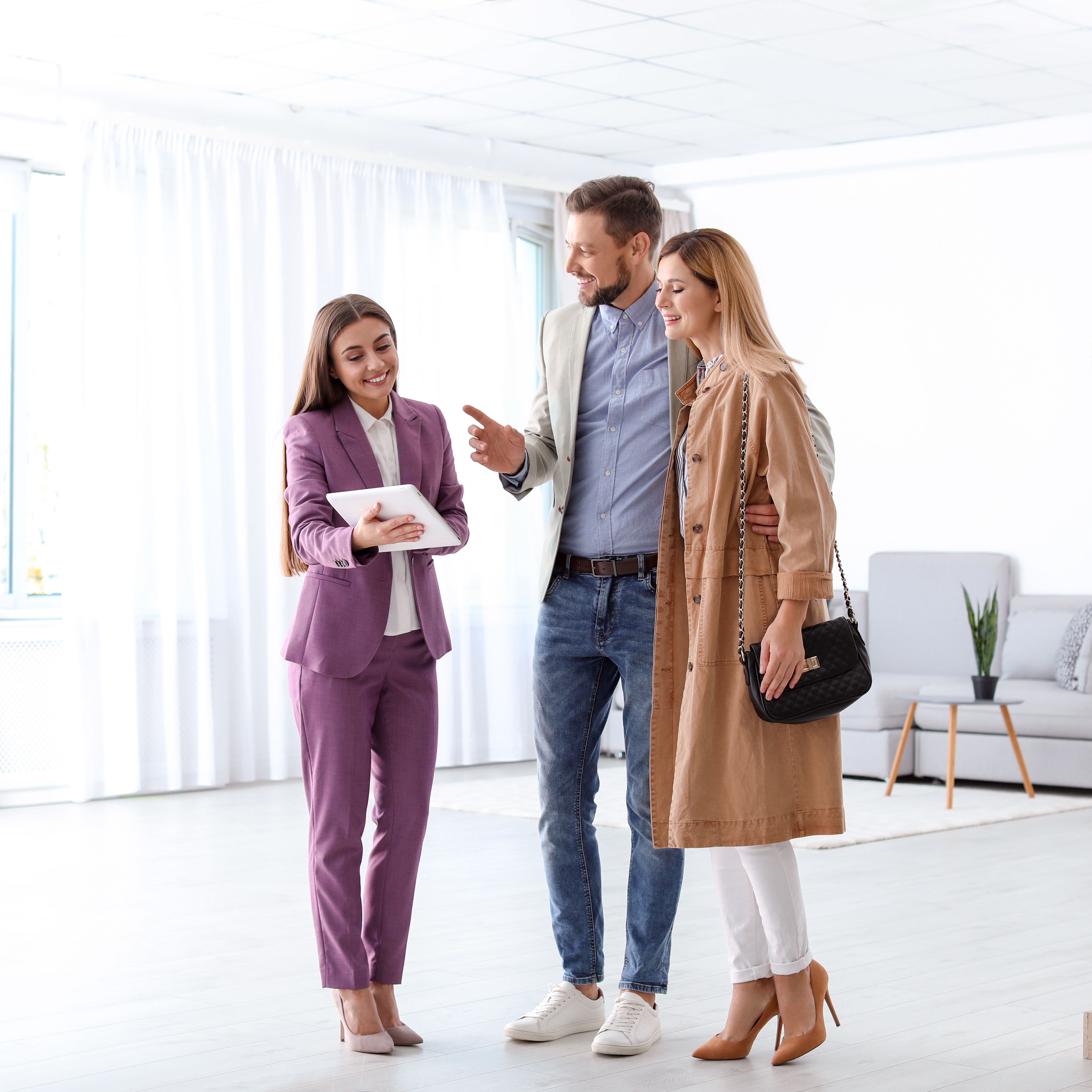 Woman in purple suit talking to couple buying a home